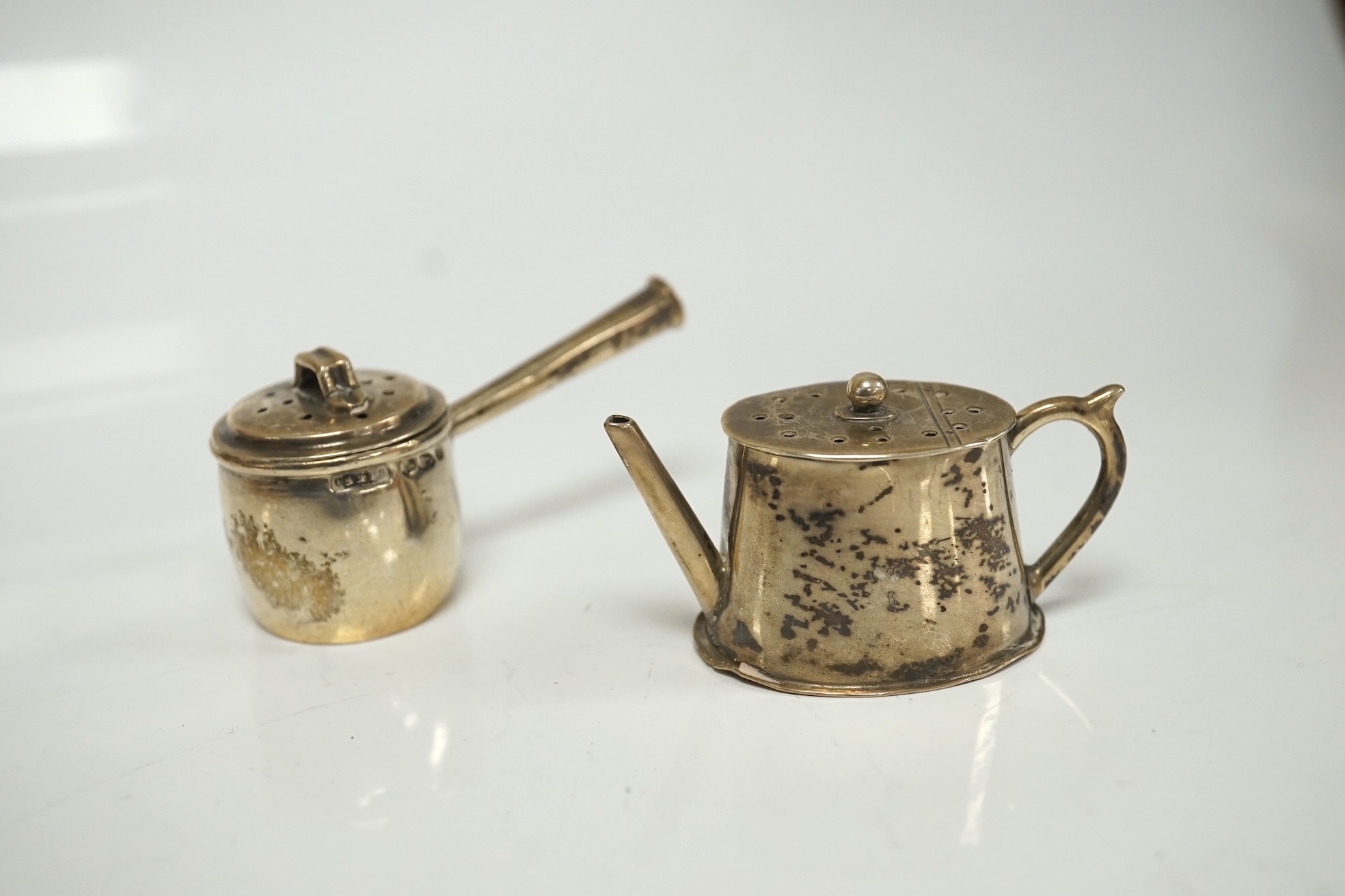 A collection of miniature silver including a three piece tea set and two handled tray by Saunders & Shepherd, Birmingham, 1904, tray 9.8cm, together with pepperettes including saucepan, candlesticks, hand mirror, etc. Co